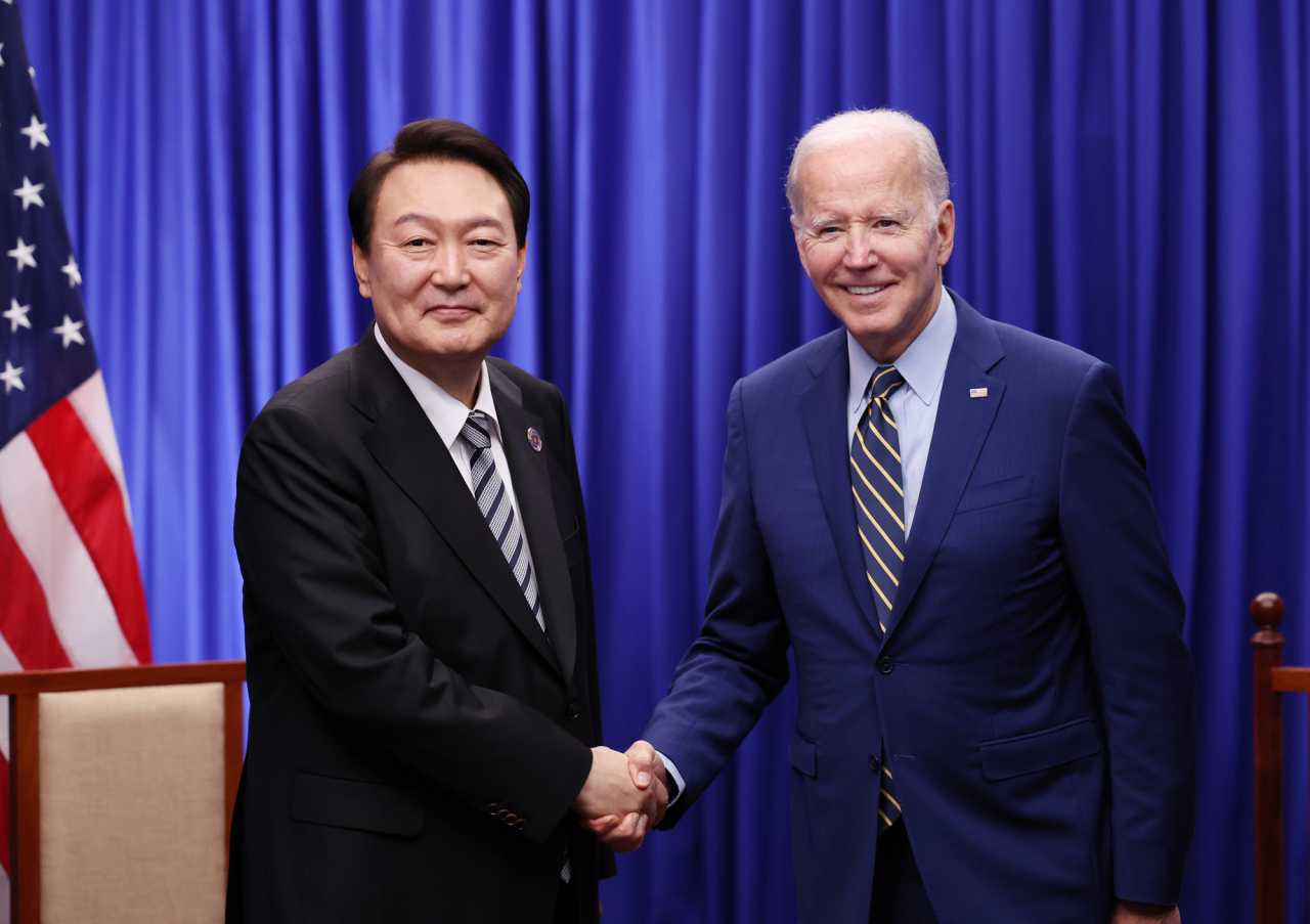 President Yoon Suk Yeol (left) shakes hands with US President Joe Biden at a summit held at a hotel in Phnom Penh, the capital of Cambodia, on Nov. 13 last year. (Yonhap)