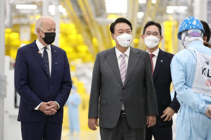 US President Joe Biden (left) and President Yoon Suk Yeol (center) take a look around Samsung Electronics' semiconductor factory in Pyeongtaek, Gyeonggi Province, under the guidance of Samsung Vice Chairman Lee Jae-yong on May 20, 2022. (Yonhap)