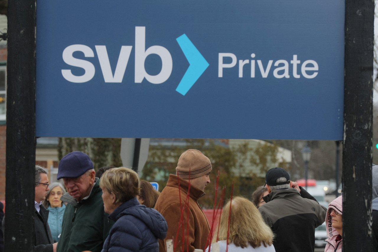 Customers wait in line outside a branch of the Silicon Valley Bank in Wellesley, Massachusetts, Monday. (Reuters-Yonhap)