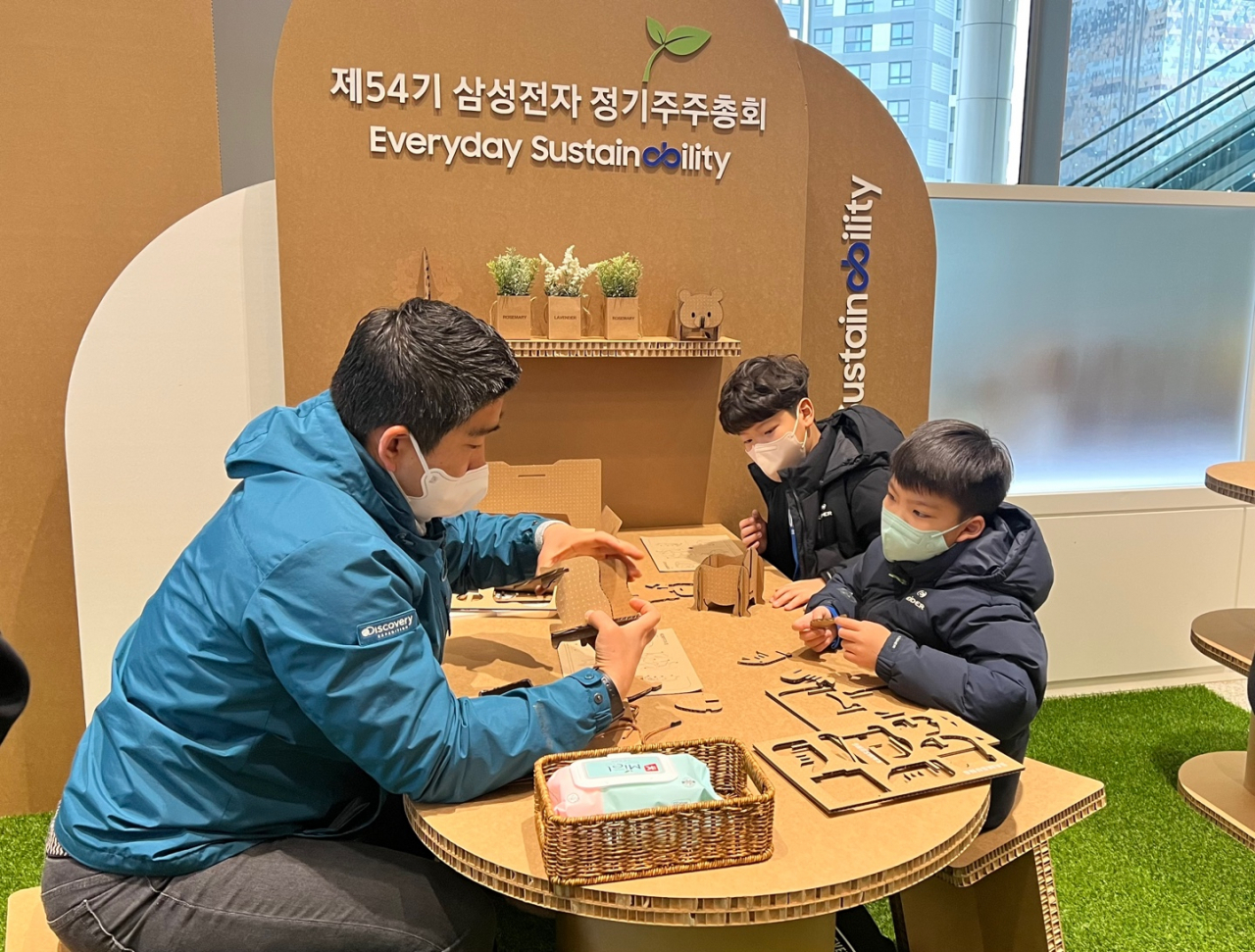 A Samsung Electronics shareholder attends the company's annual shareholders meeting with his children in Suwon, Gyeonggi Province, Wednesday. (Jo He-rim/The Korea Herald)