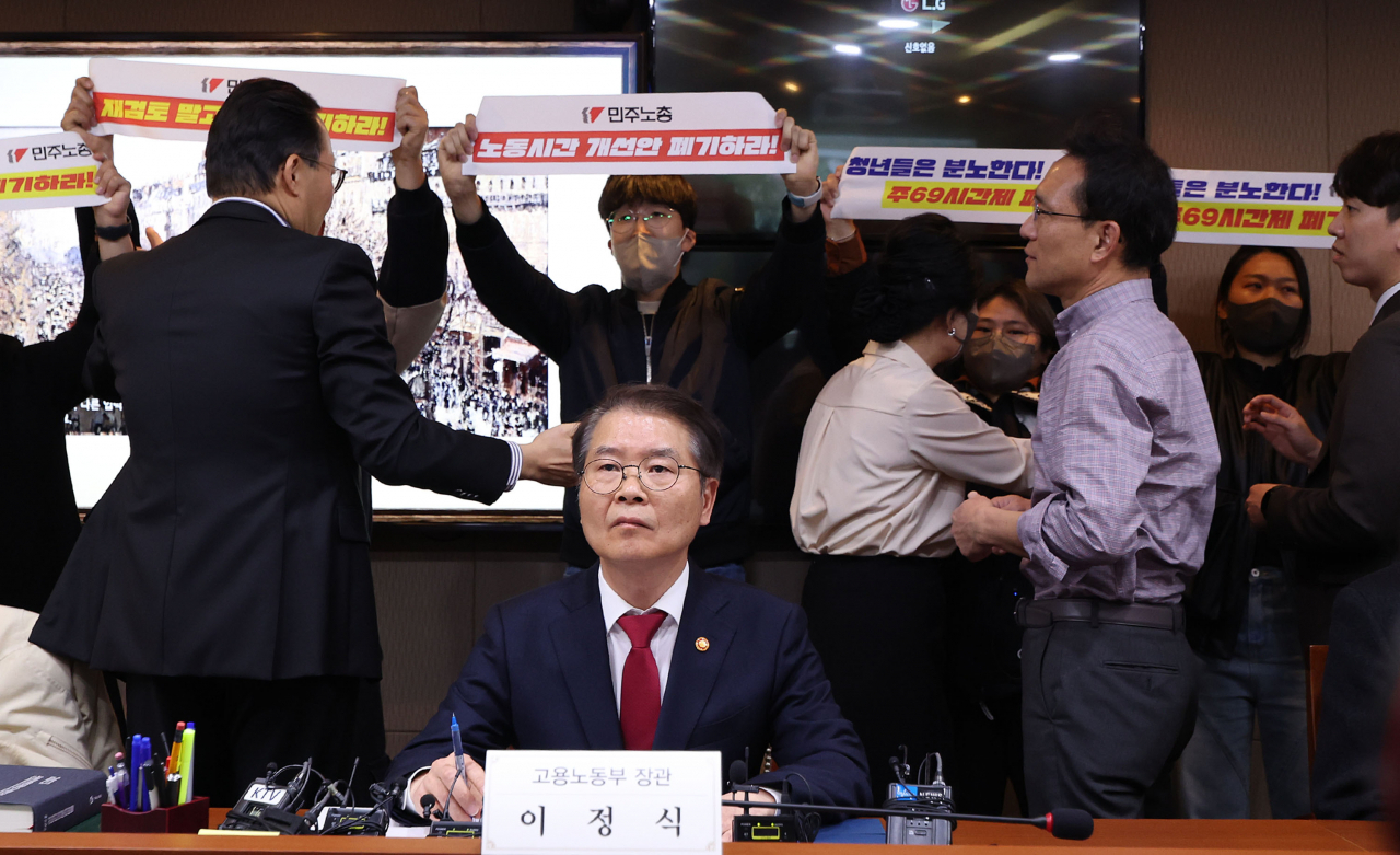 Protesters raided a venue of a meeting presided over by Labor Minister Lee Jung-sik (center, front row) at Seoul Regional Employment and Labor Office on Wednesday. (Yonhap)