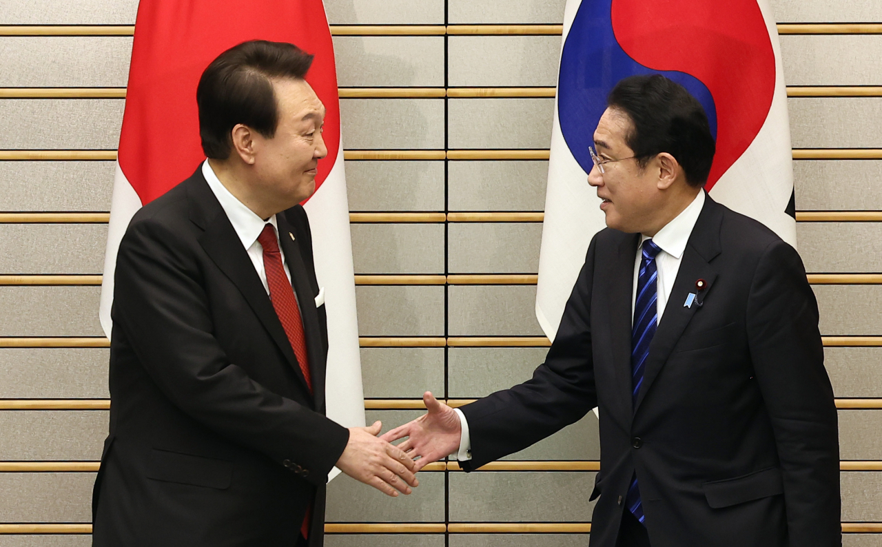 President Yoon Suk Yeol shakes hands with Japanese Prime Minister Fumio Kishida at the prime minister's office in Tokyo on Thursday prior to the summit meeting. (Yonhap)