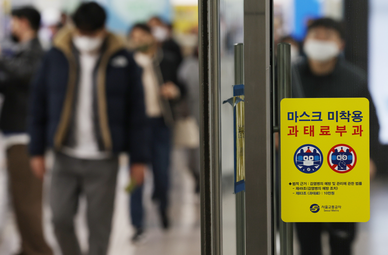 A penalty notice for noncompliance with the mask-wearing policy on public transportation is glued to a glass door at Gwanghwamun Station in central Seoul on Wednesday. South Korea will remove the mask requirement for public transportation on March 20. (Yonhap)