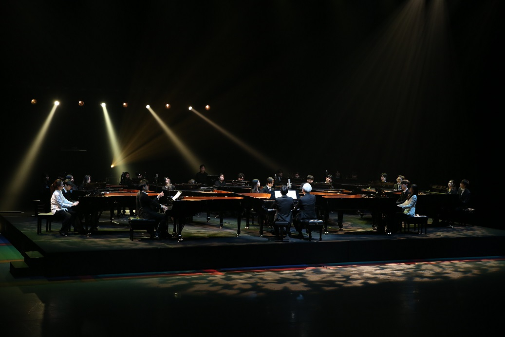 Students and alumni from the piano department, together with K-Arts President Kim Dae-jin, perform as a piano-only orchestra during the 30th anniversary celebration event at Seokgwan Campus in northeast Seoul on Thursday. The orchestra was formed with 15 pianos and 30 pianists. (K-Arts)