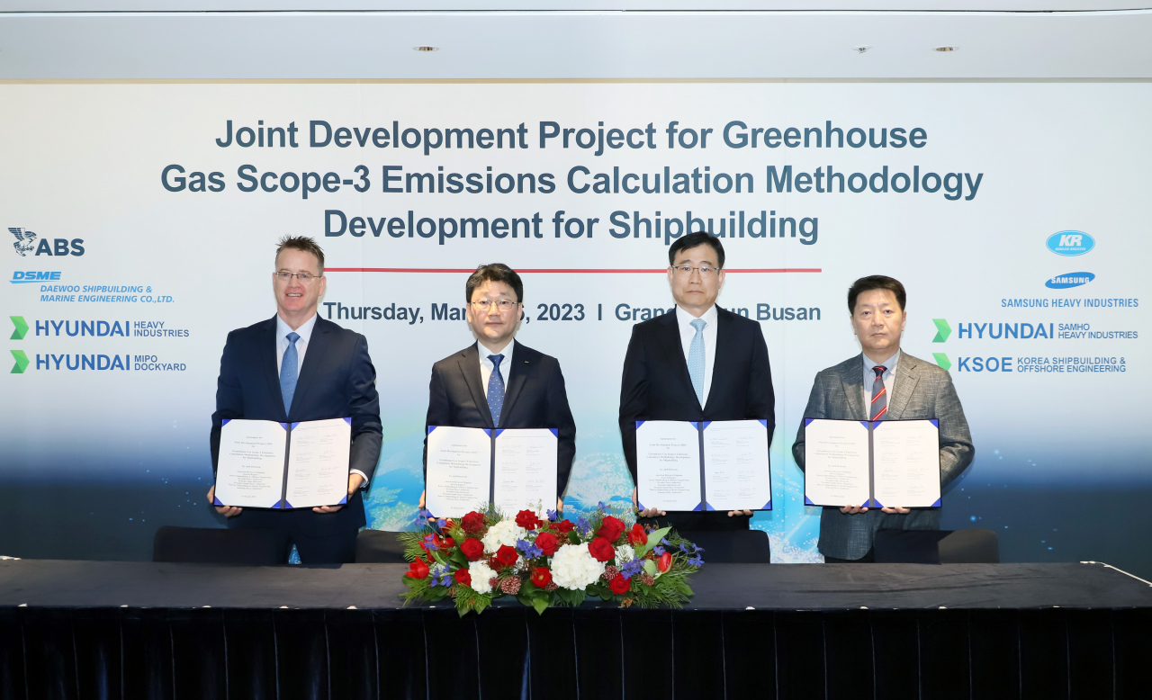 Representatives from Korea Shipbuilding & Marine Engineering, Daewoo Shipbuilding & Marine Engineering, Samsung Heavy Industries, the American Bureau of Shipping, and the Korean Register of Shipping, pose after signing an agreement for carbon neutrality at a hotel in Busan on Thursday. (HD Hyundai)