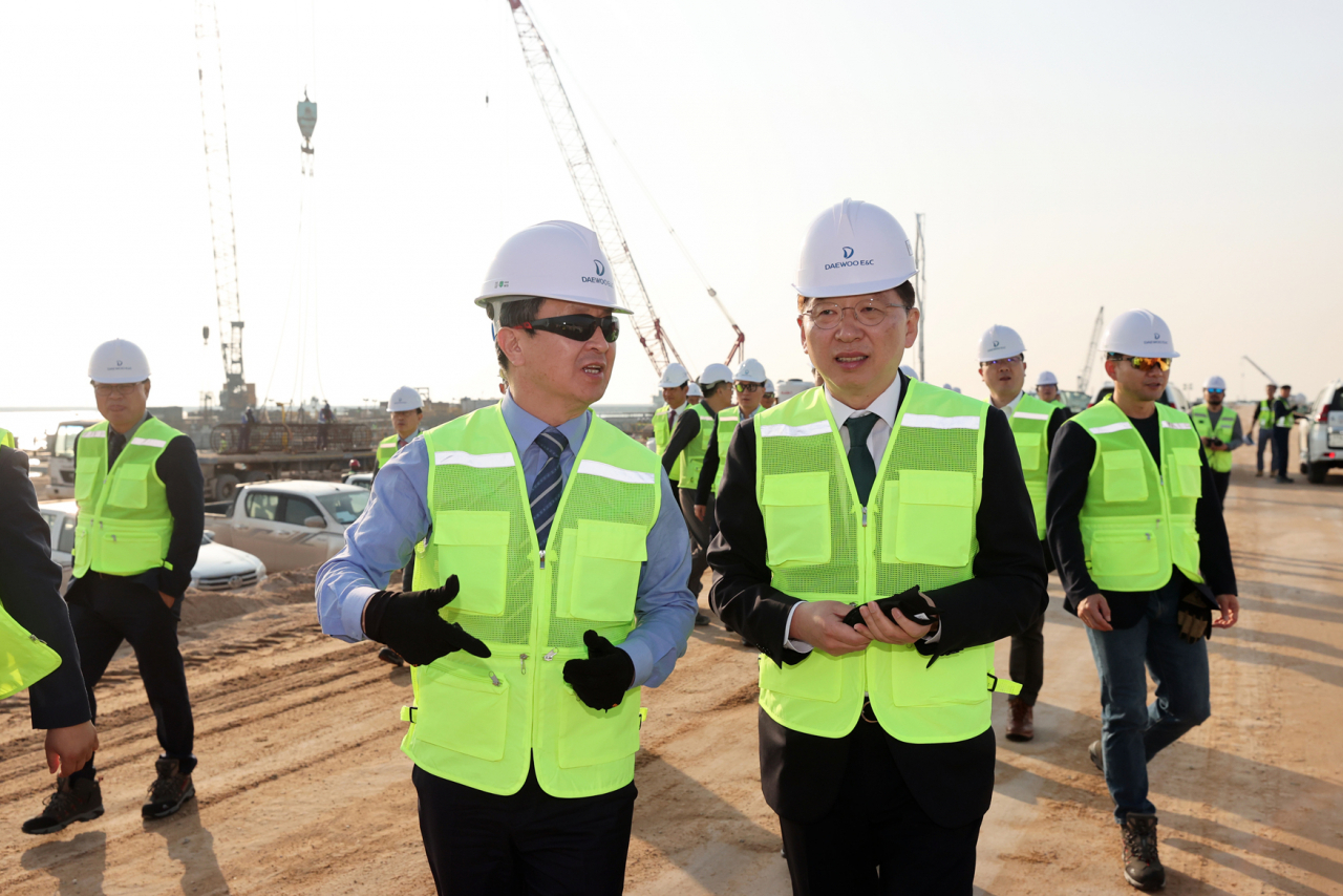 Daewoo Engineering & Construction CEO Baek Jung-wan (left) and Oceans and Fisheries minister Cho Seung-hwan (right) walk in construction site at the Al Faw Port on Tuesday. (Daewoo E&C)