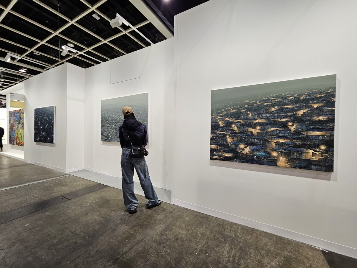 A visitor looks at paintings by Korean artist Joung Young-ju presented by Hakgojae at Art Basel Hong Kong on Tuesday at the Hong Kong Convention and Exhibition Centre. (Park Yuna/The Korea Herald)