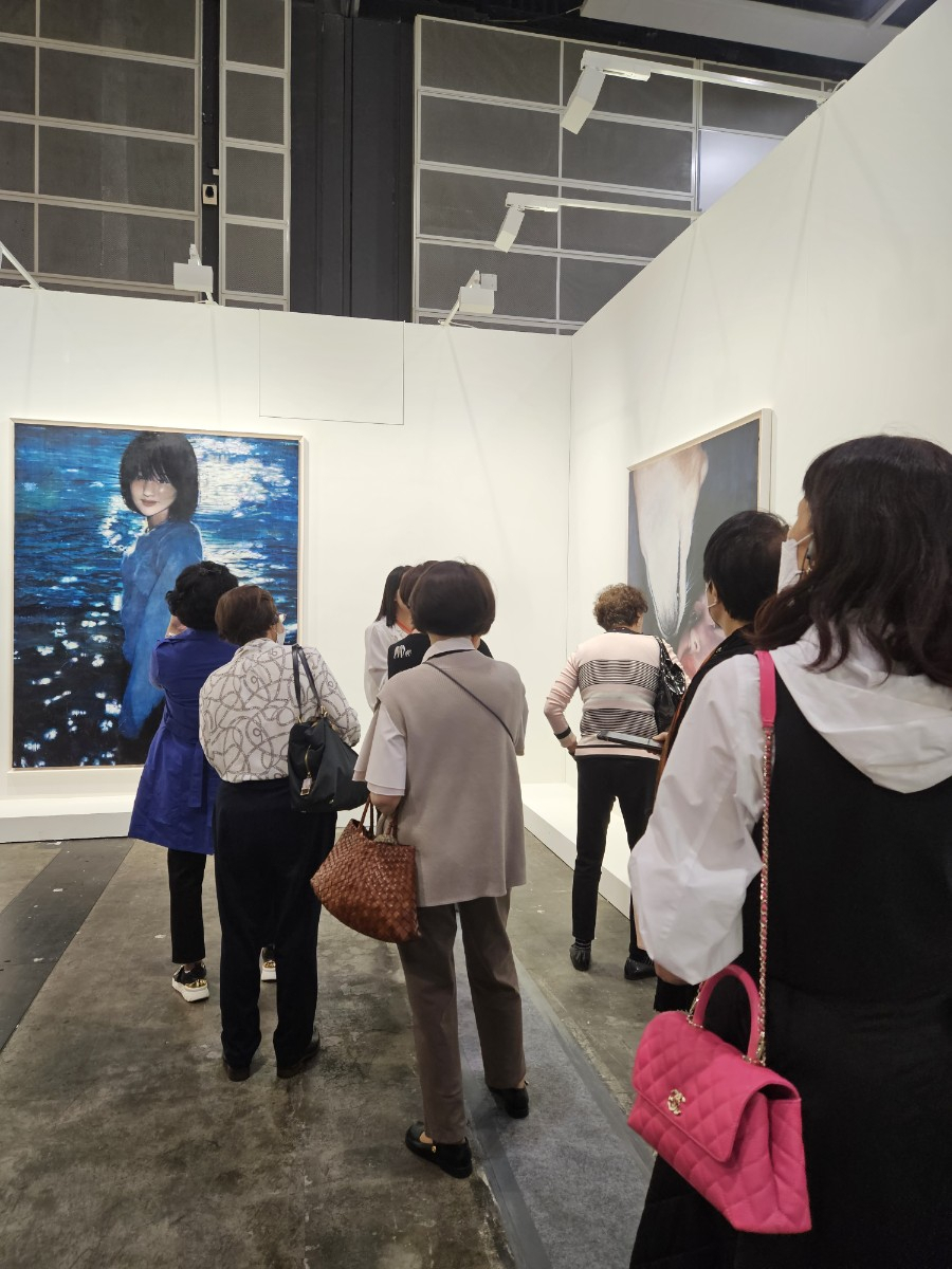 Fairgoers look at paintings by Moka Lee presented by Jason Haam on Tuesday at the Hong Kong Convention and Exhibition Centre. (Park Yuna/The Korea Herald)