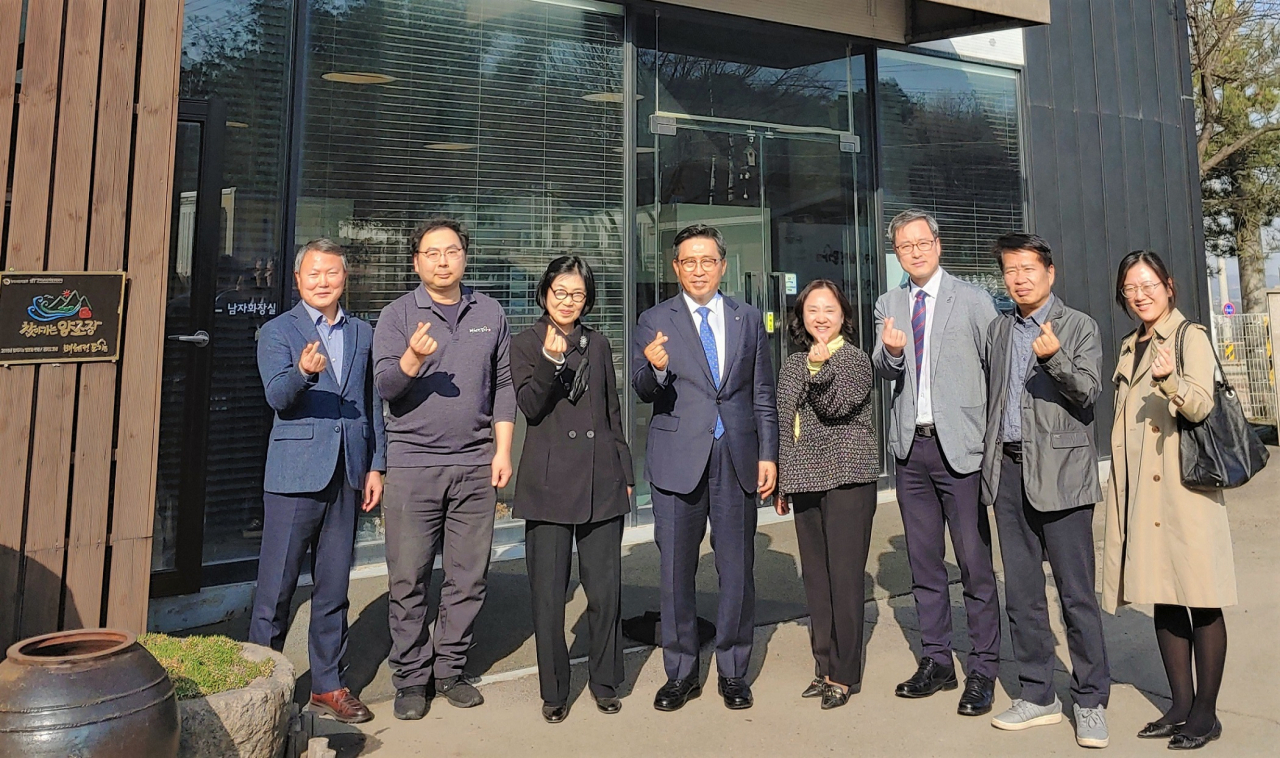 Korea Agro-Fisheries and Food Trade Corporation CEO Kim Chun-jin (fourth from left) and BHD CEO Bae Hae-jung (third from left) pose for a photo during Kim's visit to BHD's brewery in Hwaseong. (Korea Agro-Fisheries and Food Trade Corporation)