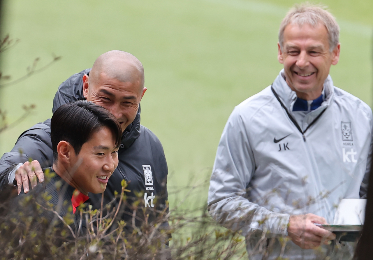 Jurgen Klinsmann (right), head coach of the South Korean men's national football team, watches his midfielder Lee Kang-in (left) chat with technical adviser Cha Du-ri before a training session at the National Football Center in Paju, 30 kilometers northwest of Seoul, on Wednesday. (Yonhap)