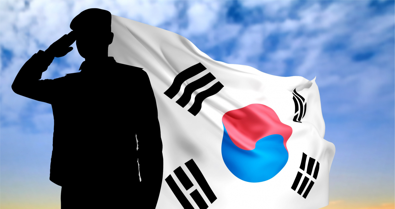 A silhouette of a soldier saluting with South Korea flag on background (123rf)