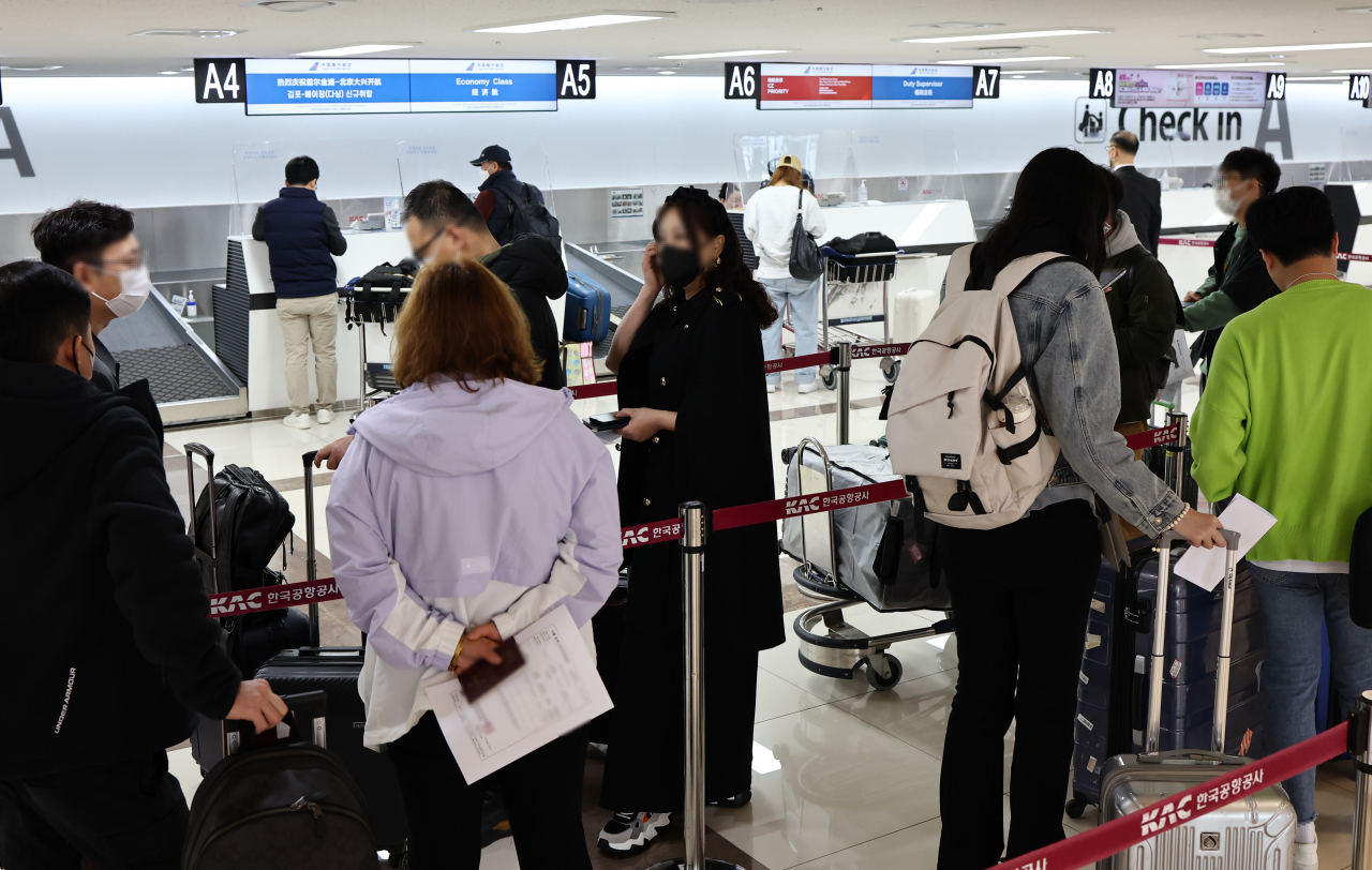 Passengers line up at a China Southern Airlines check-in desk at Gimpo International Airport, just west of Seoul, on Sunday when China reopened a route between Gimpo and Beijing (Yonhap)