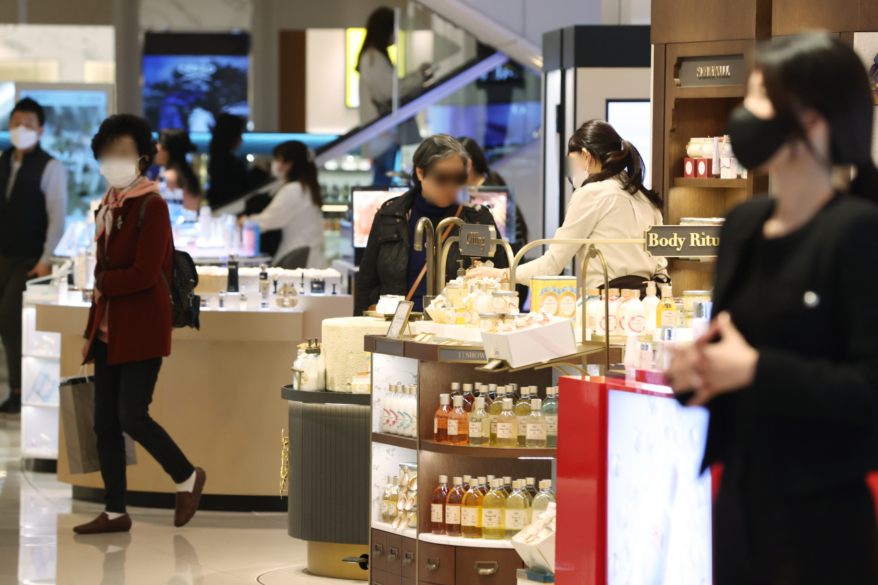 Visitors shop at a department store in Seoul. (Yonhap)