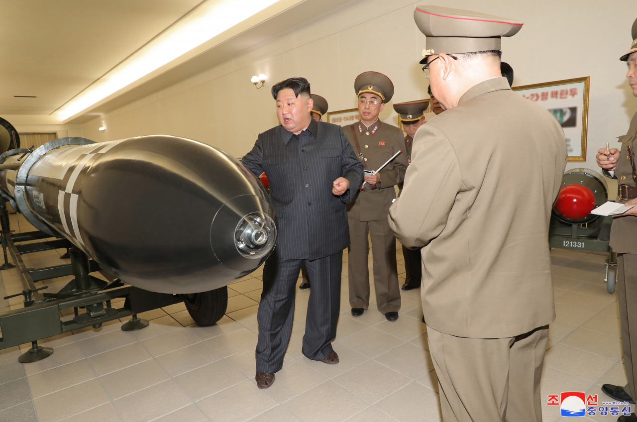 North Korean leader Kim Jong-un (black suit) inspects missiles at a nuclear weapons institute on Monday in this photo released by the Korean Central News Agency on Tuesday. (KCNA-Yonhap)