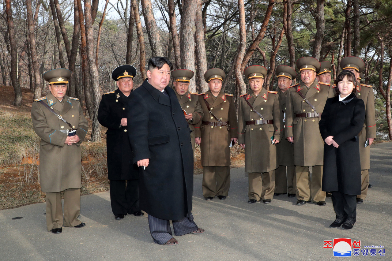 North Korean leader Kim Jong-un (third from left) inspects the Hwasong artillery unit with his daughter, presumed to be his second child, Ju-ae, on Thursday. (KCNA)