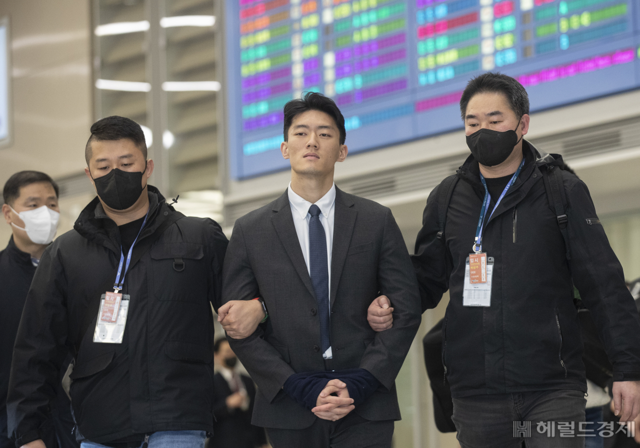 Chun Woo-won, former President Chun Doo-hwan’s grandson, enters the arrival gate of Incheon International Airport Terminal 2, wearing handcuffs, Tuesday. (Herald Business)