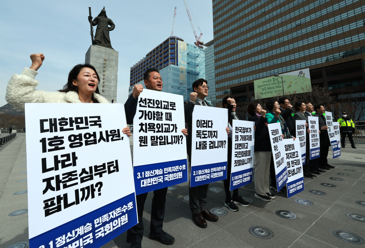 This file photo from Mar. 17 shows Rep. Kim Sang-hee and other main opposition Democratic Party lawmakers holding signs at Gwanghwamun Plaza in central Seoul protesting against the government's decision to compensate victims of Japan's wartime forced labor on its own, without asking Japan for contributions. (Yonhap)
