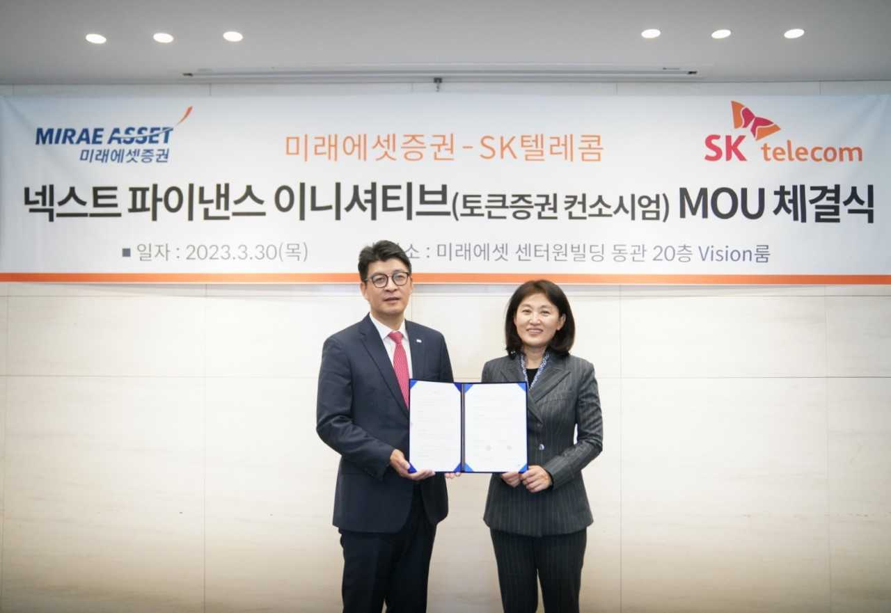 Ahn In-seong (left), head of the digital division at Mirae Asset Securities, and Oh Se-hyun, head of SK Telecom's Web3 business, pose for photos after agreeing to form the Next Finance Initiative consortium at Mirae Asset Center 1 in central Seoul, Thursday. (Mirae Asset Securities)