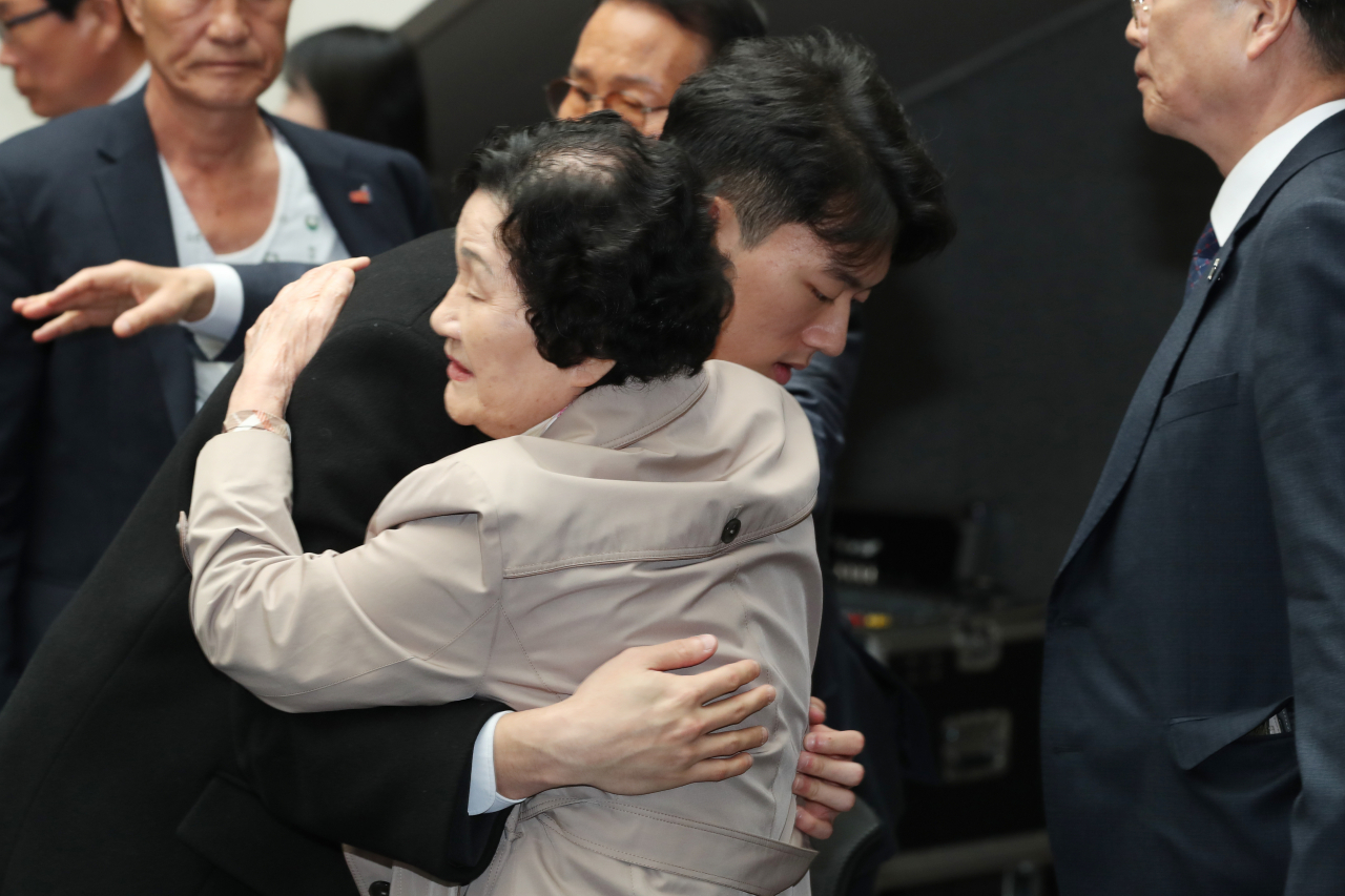 Chun Woo-won, grandson of the late former military dictator Chun Doo-hwan, consoles Kim Gil-ja, who lost a loved one during the May 18 Gwangju Democratic Uprising, on behalf of his grandfather on Friday. (Yonhap)