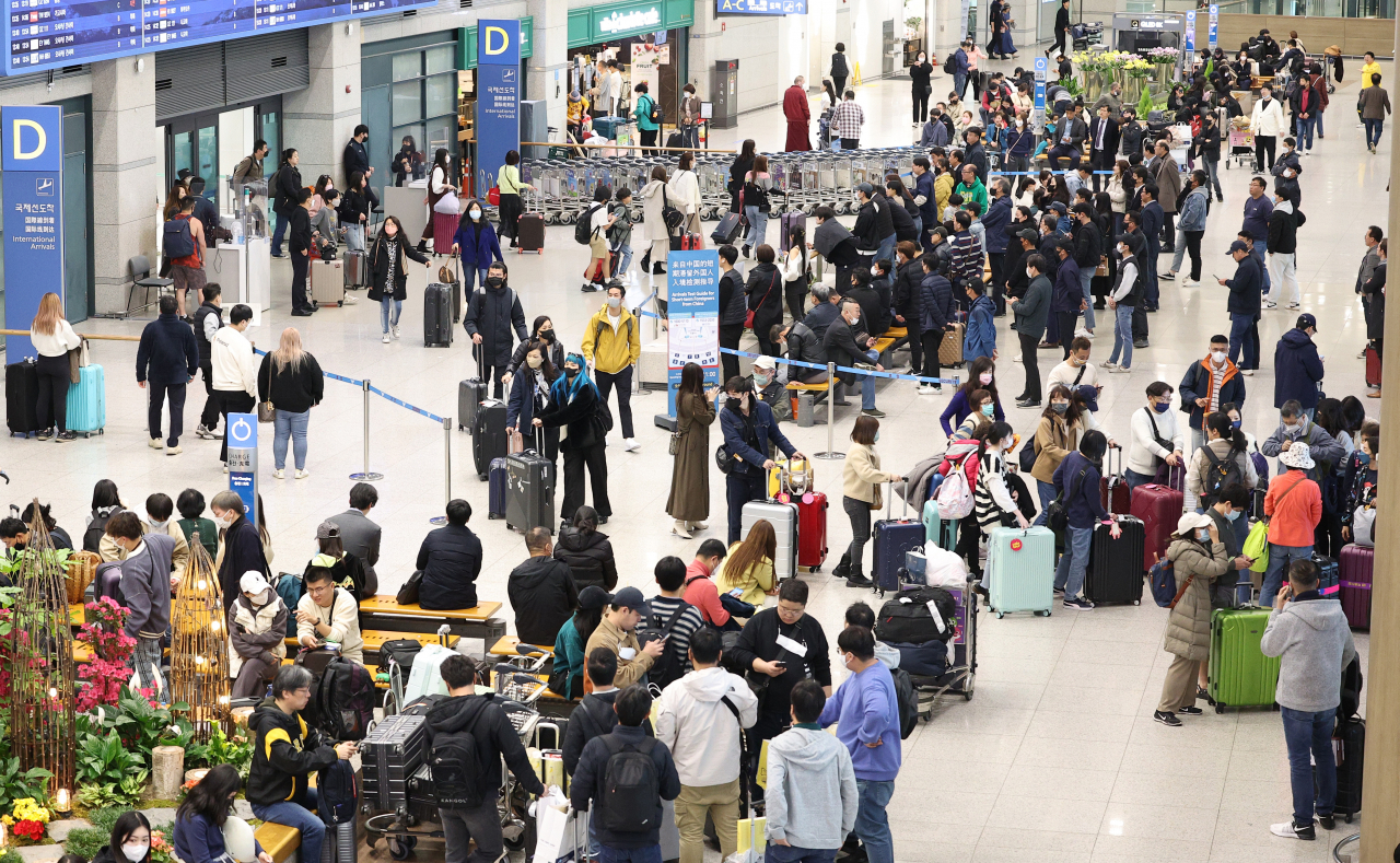 Incheon Airport is crowded with passengers and visitors on March 20. (Yonhap)