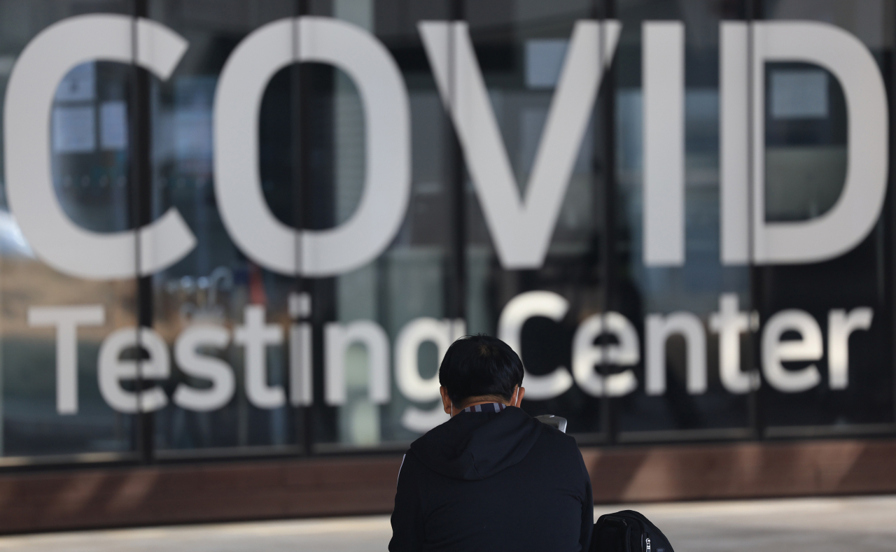 A man sits in front of a coronavirus testing center at Incheon International Airport, west of Seoul, on last Wednesday. (Yonhap)