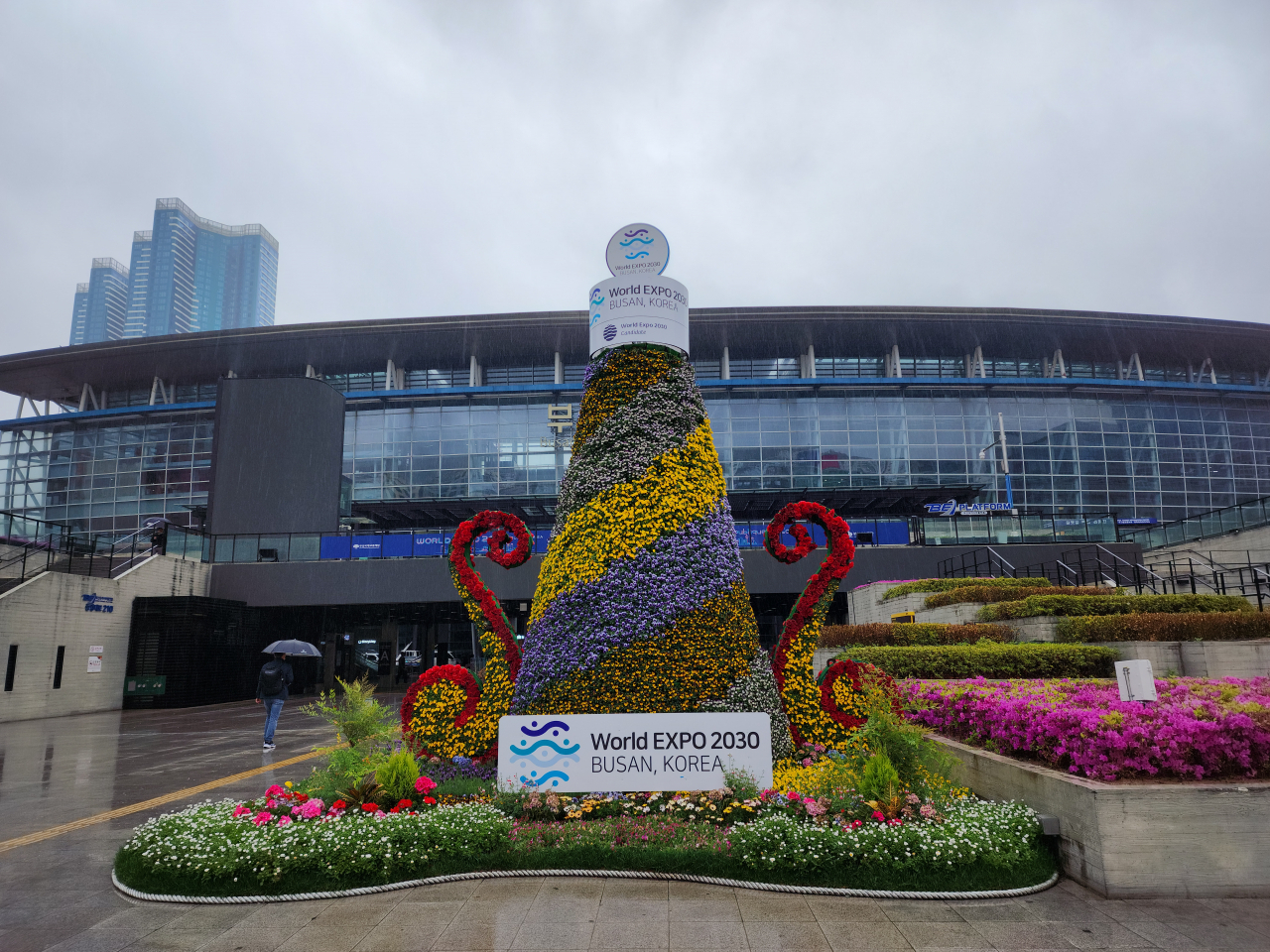 A flower display adorned with posters promoting the country's bid to host the 2030 World Expo is exhibited in front of Busan Station, Wednesday. (Lee Yoon-seo/The Korea Herald)