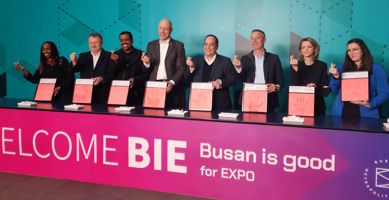 The Bureau International des Expositions (BIE) inspection team, led by the head of the BIE's administration and budget committee, Patrick Specht from Germany (fourth from left), poses for a photo after taking part in a hand printing ceremony. (Lim Se-jun/The Korea Herald)