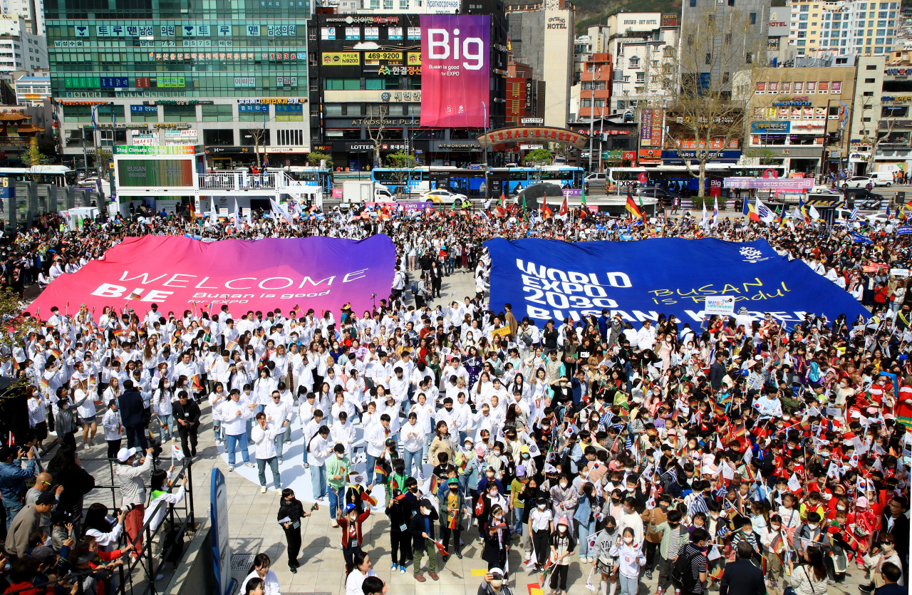 Busan citizens hold up placards welcoming Bureau International des Expositions (BIE)'s visit to Busan at Busan Station, Tuesday. (Yonhap)