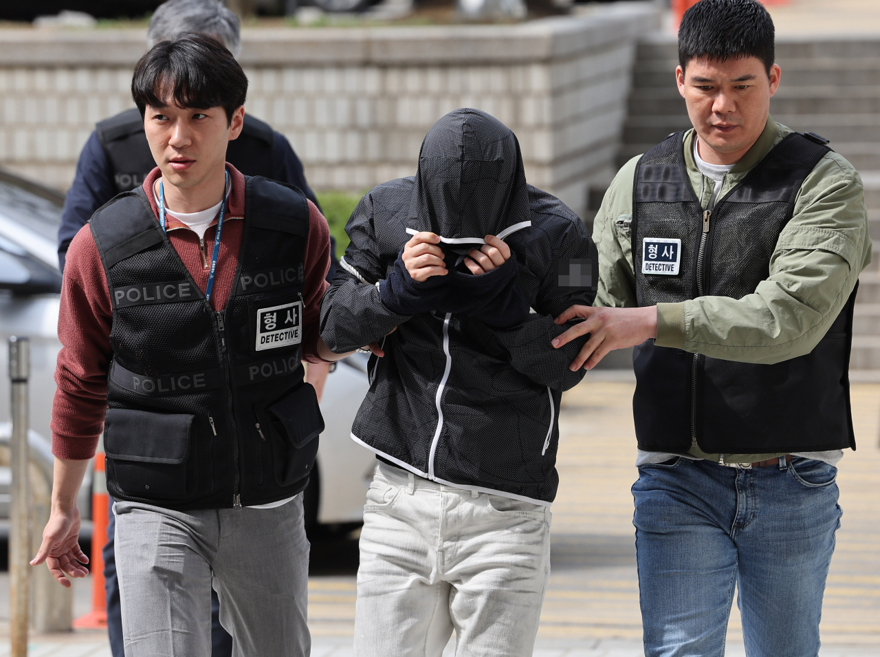 A man surnamed Yoo (second from left), suspected of being the mastermind behind a recent kidnapping and murder of a woman, is taken to the Seoul Central District Court on Friday for a hearing to review the police's request for a warrant to arrest him. (Yonhap)