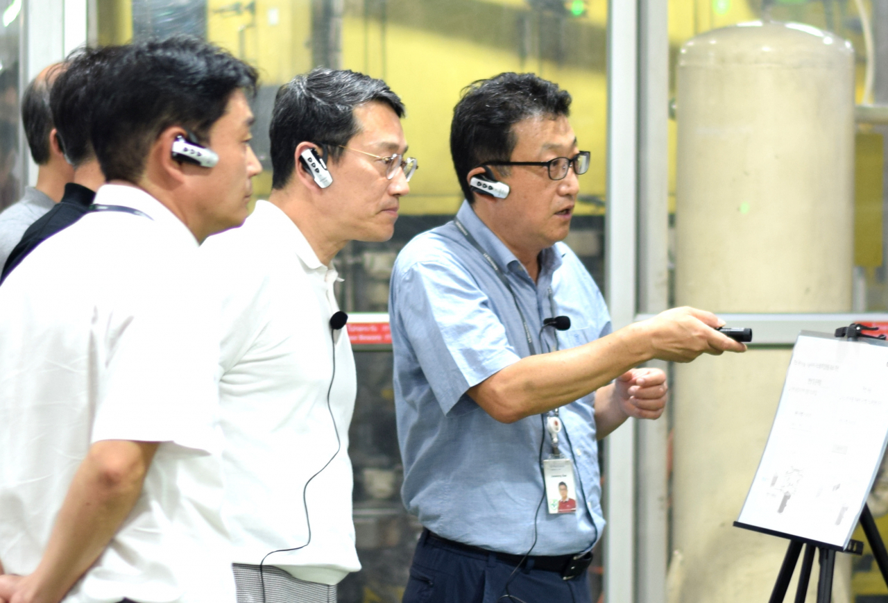 LG Electronics Chief Executive Officer Cho Joo-wan (center) listens to a briefing at the company's home appliances production line in Rayong, Thailand, on April 4. (LG Electronics)