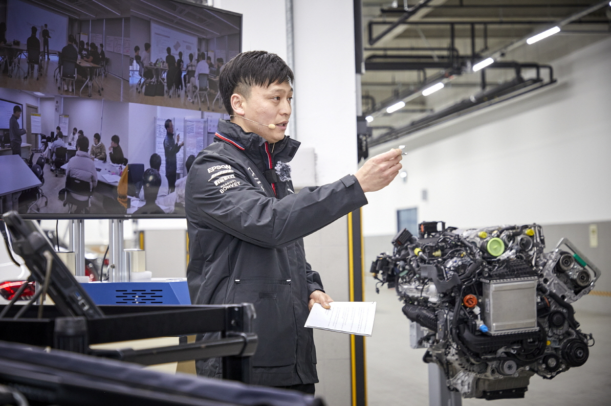 Kim Min-jun, a certified Mercedes-Benz technician, explains how workbays operate at Han Sung Motor's Seongdong Service Center in Seoul on Thursday. (Han Sung Motor)