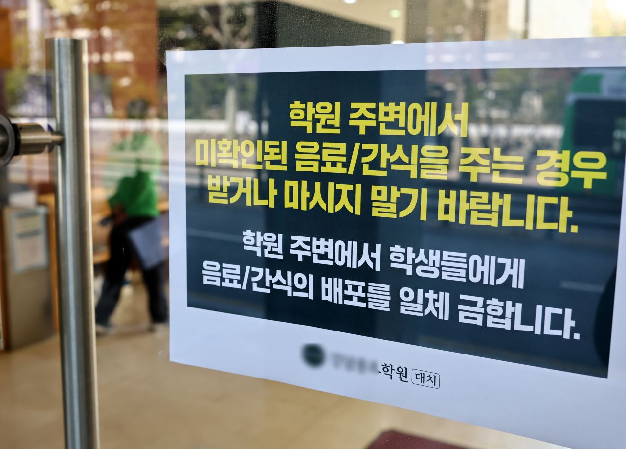 A notice warning students not to accept drinks or food from strangers is put up at a private academy in Daechi-dong, Gangnam-gu, Seoul, Sunday. (Yonhap)