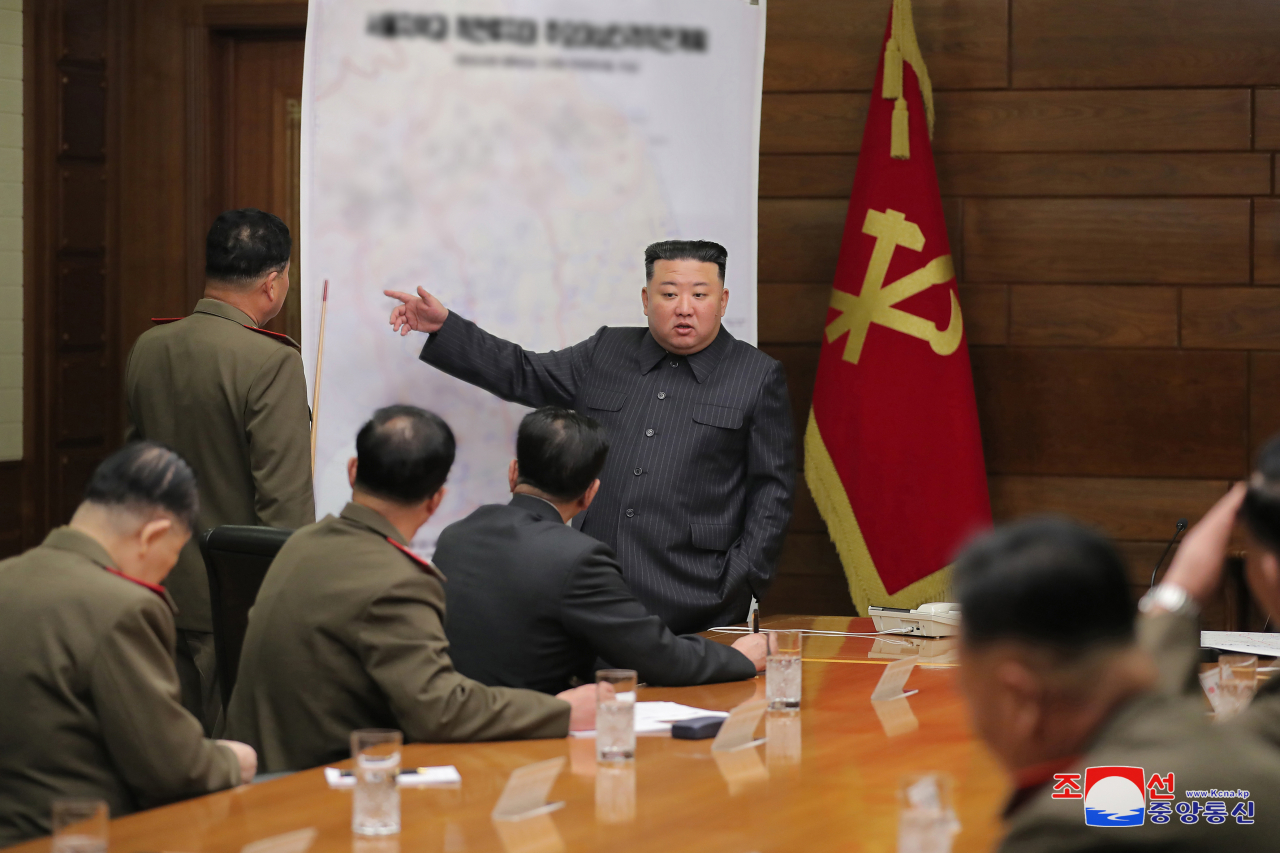North Korean leader Kim Jong-un (standing, R) speaks during a meeting of the central military commission of the ruling Workers' Party on April 10, 2023, in this photo provided by the North's official Korean Central News Agency. (Yonhap)