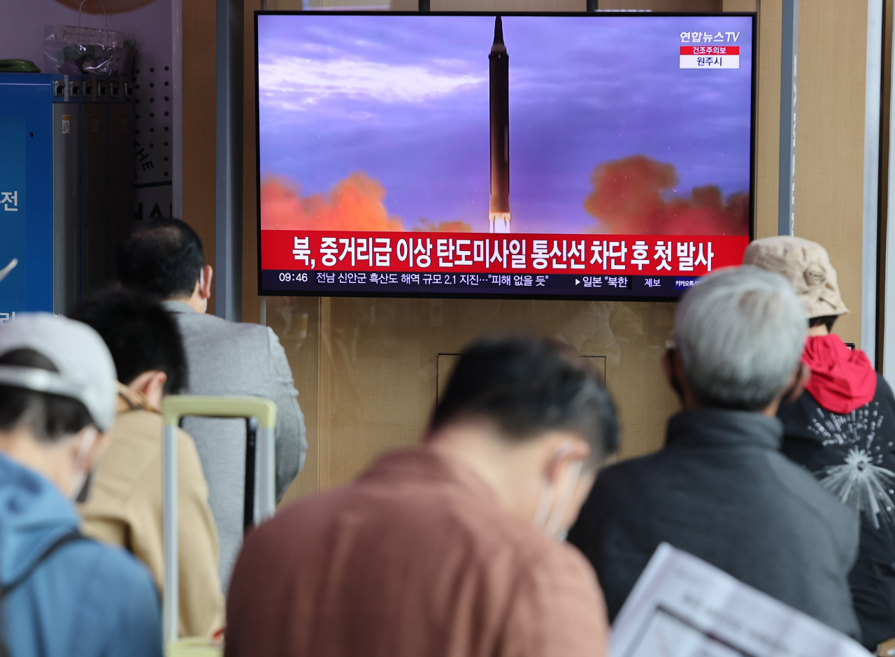 People watch a TV report on North Korea's launch of an intermediate- or long-range ballistic missile toward the East Sea at Seoul Station on April 13, 2023. The Joint Chiefs of Staff said it detected the launch in the vicinity of Pyongyang at 7:23 a.m. (Yonhap)