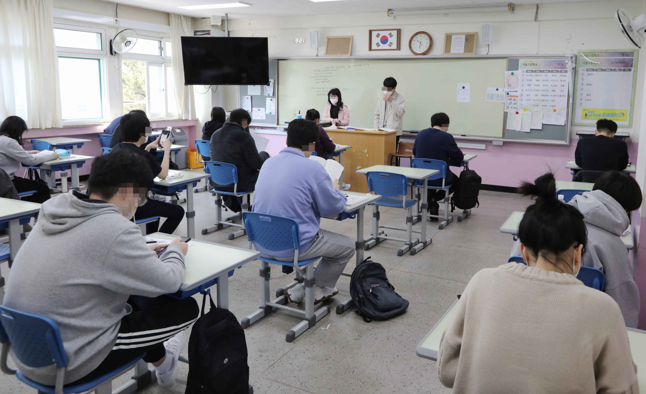 Applicants for the grade nine public servant job take a written test at a school in Seocho-gu, Seoul on April 8. (Yonhap)