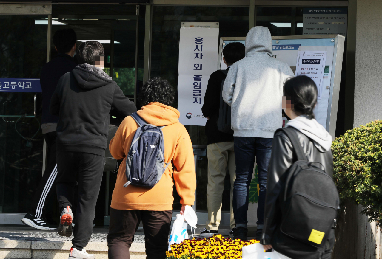 Applicants for the grade nine public servant job arrive at school in Seocho-gu, Seoul on April 8, where they will take a written test. (Yonhap)