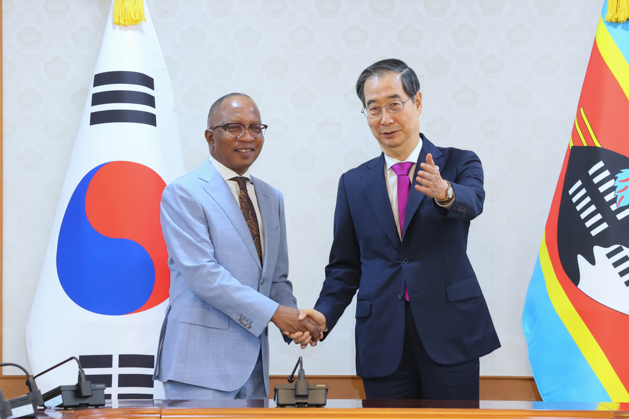 South Korea's Prime Minister Han Duck-soo (right) shakes hands with Eswatini counterpart Cleopas Dlamini during talks at the Government Complex Seoul on Friday. (Prime Minister's office)