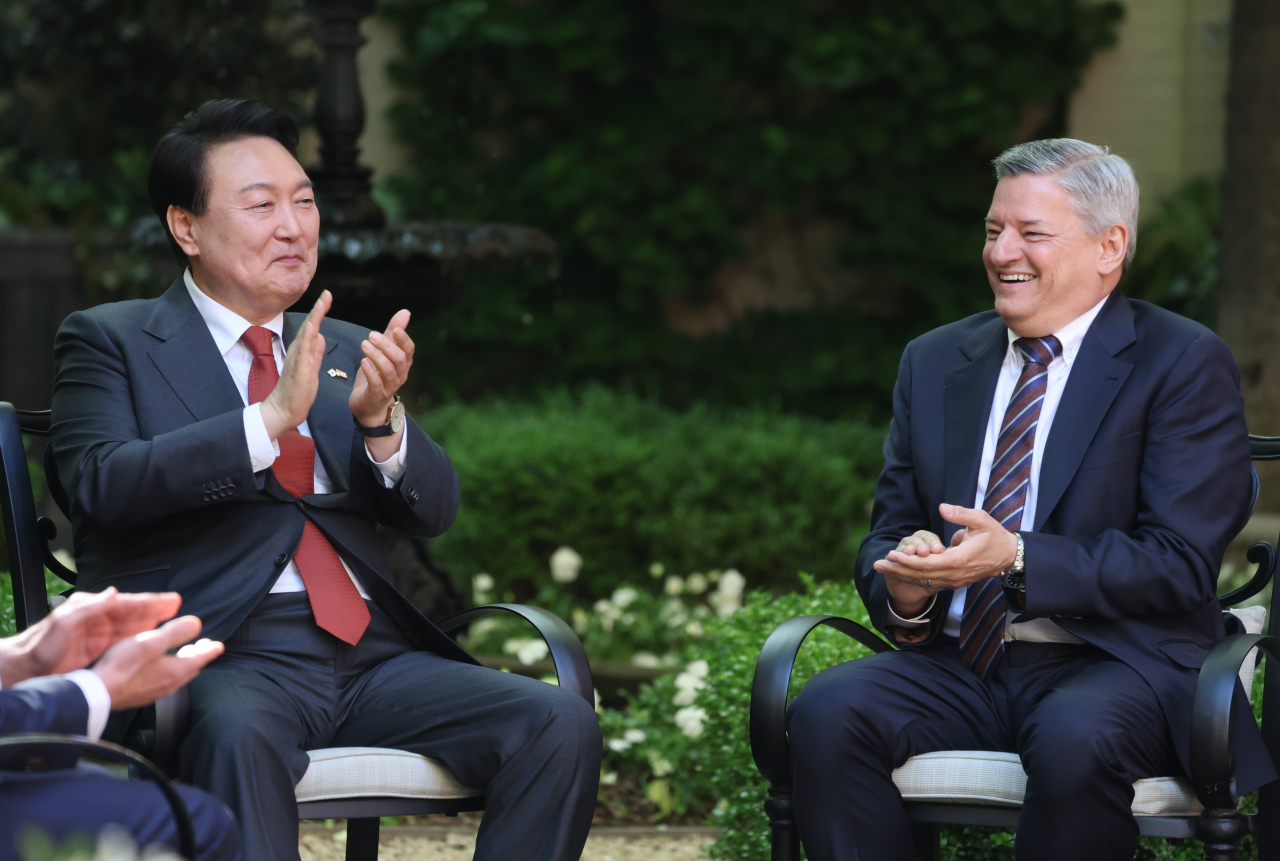 President Yoon Suk Yeol (left) talks with Netflix chief Ted Sarandos at the White House Conference Center on Monday. (Yonhap)