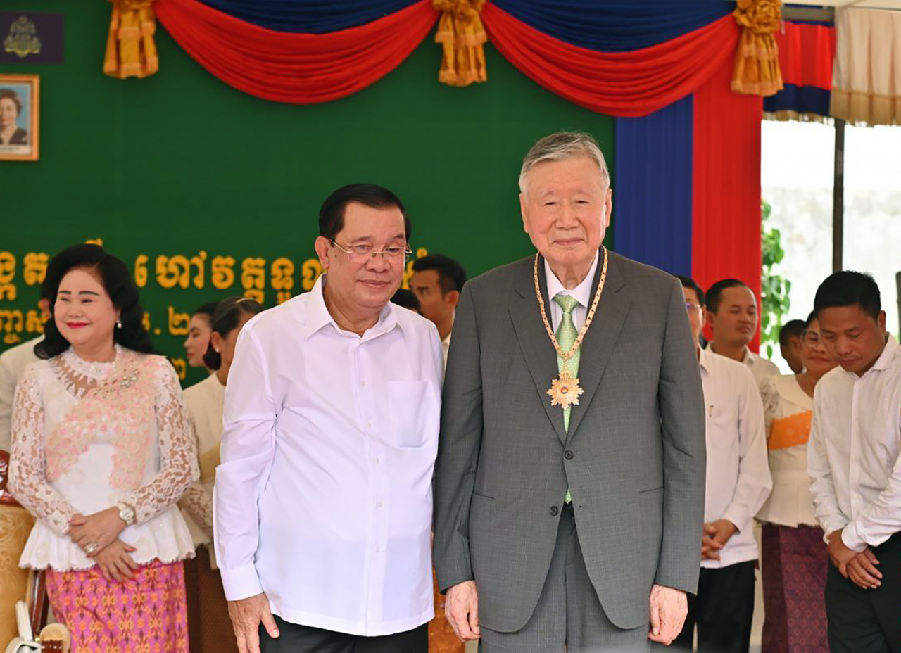 Booyoung Group Founder and Chairman Lee Joong-keun (right) poses for a photo with Cambodian Prime Minister Hun Sen after receiving the Medal of National Merit for his contributions to the country's national development in Phnom Penh on Monday. (Booyoung Group)