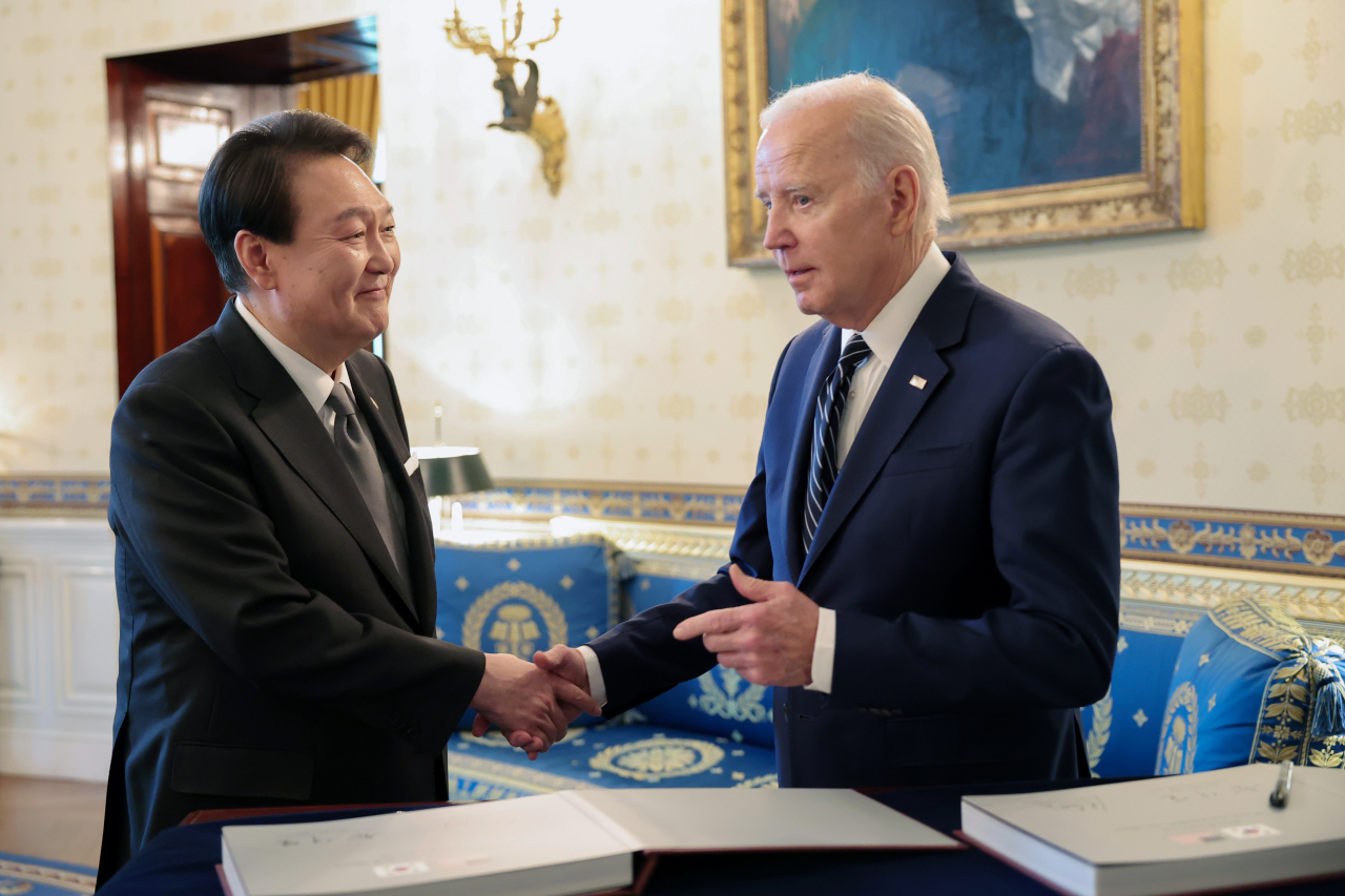 South Korean President Yoon Suk Yeol (left) shakes hands with US President Joe Biden at the White House in Washington on Tuesday. (Yonhap)