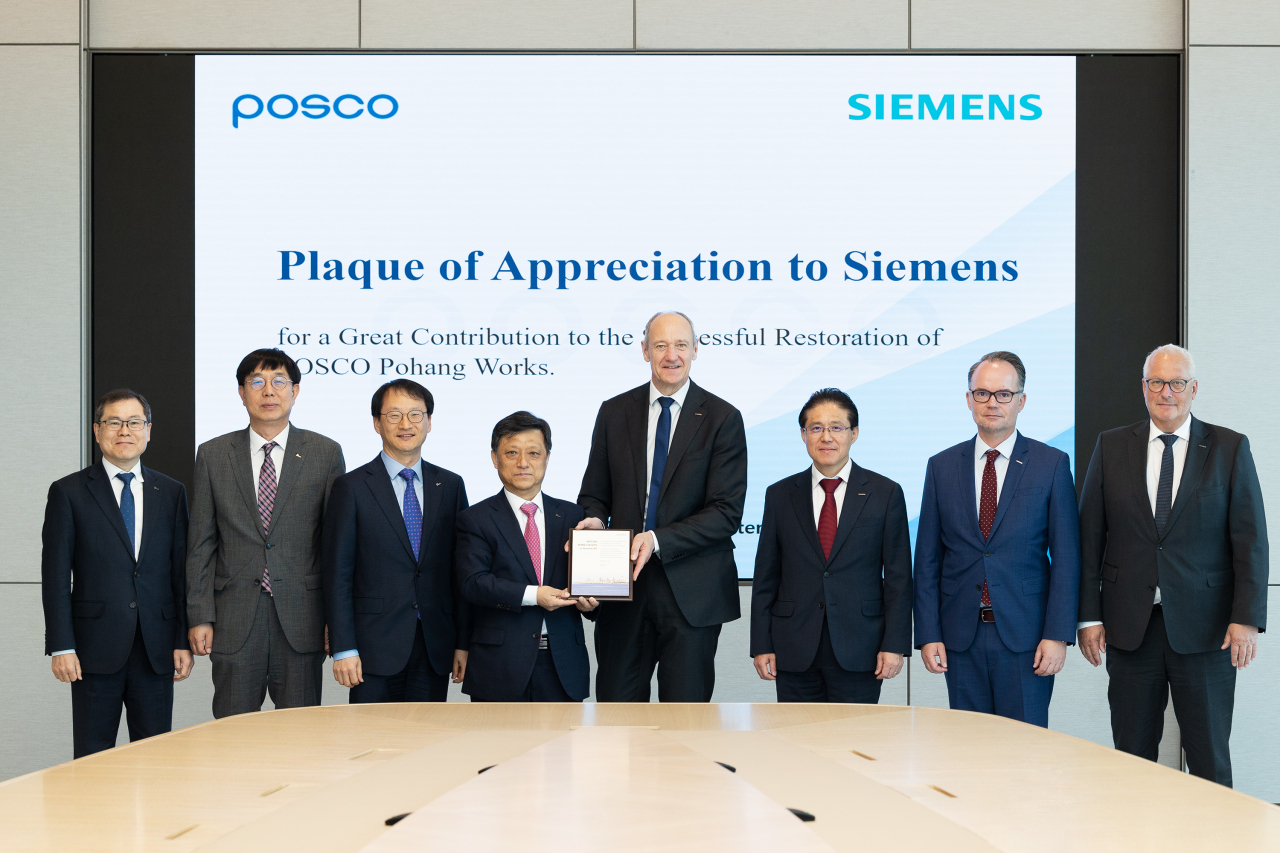 Posco Group Vice Chairman Kim Hak-dong (fourth from left) and Siemens CEO Roland Busch (fifth from left) pose for a photo after a plaque-delivering ceremony at the Posco Center in Seoul, Tuesday. (Posco Group)