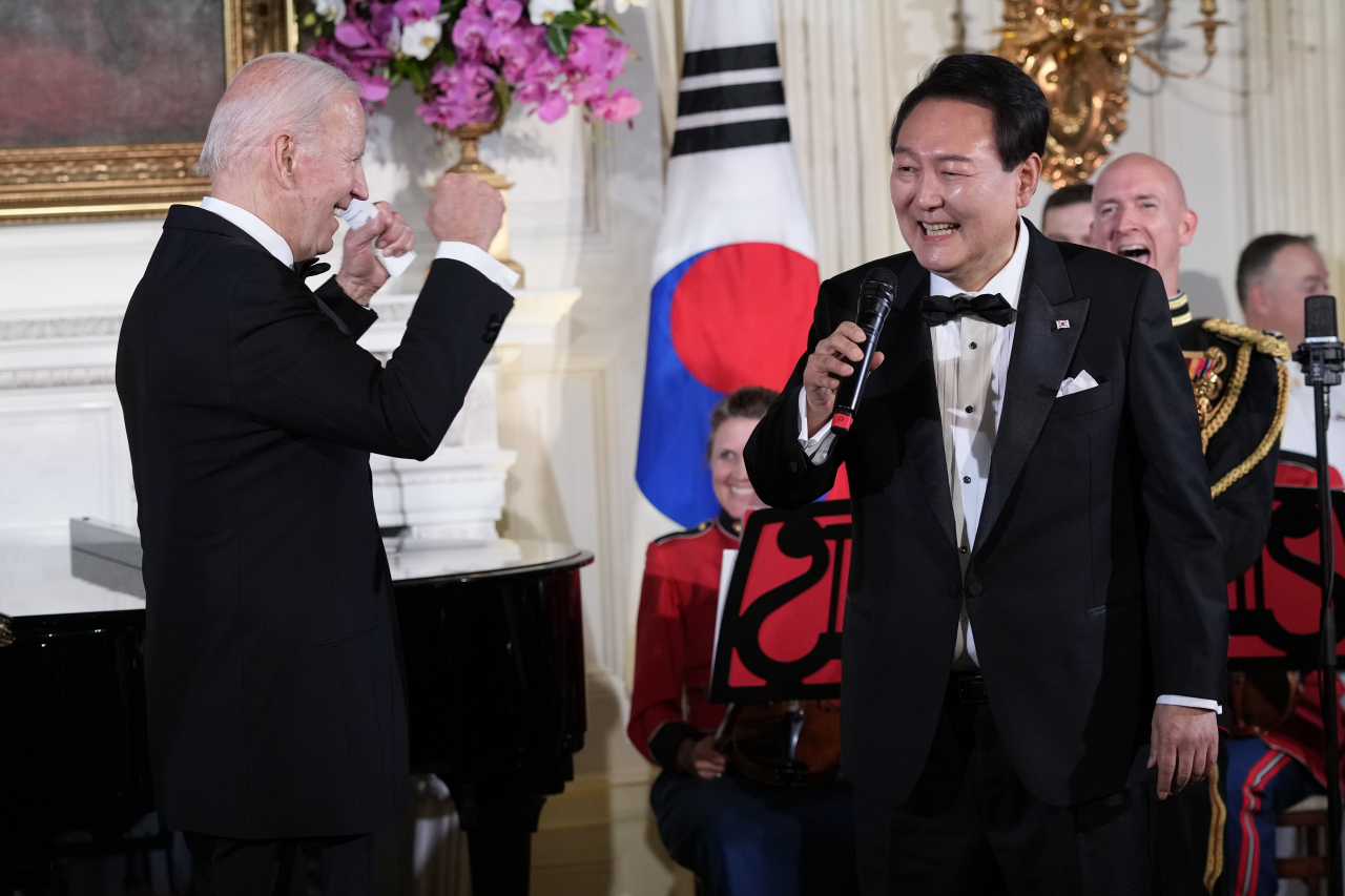 US President Joe Biden reacts as South Korean President Yoon Suk Yeol sings 