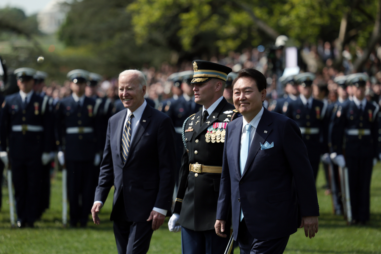South Korean President Yoon Suk Yeol (right) and US President Joe Biden inspect an honor guard at an official welcoming event ahead of their summit at the White House in Washington, D.C., Tuesday. (Yonhap - Pool photo)