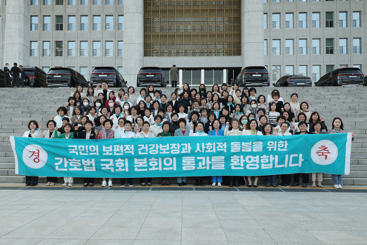 Korean Nurse Association members and the ruling People Power Party representative Choi Yeon-suk pose for a photo at the National Assembly, celebrating the passing of the nursing act on Thursday. (Yonhap)