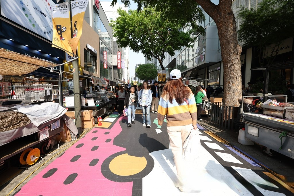 People walk on a street in Myeongdong, downtown Seoul, ahead of the Myeongdong Festival on Thursday. (Yonhap)