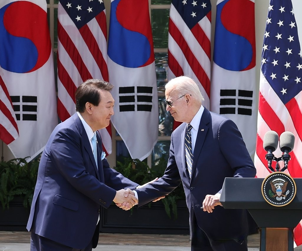 South Korean President Yoon Suk Yeol (left) shakes hands with US President Joe Biden during a joint news conference after their summit at the White House in Washington, DC, on Wednesday. (Yonhap)