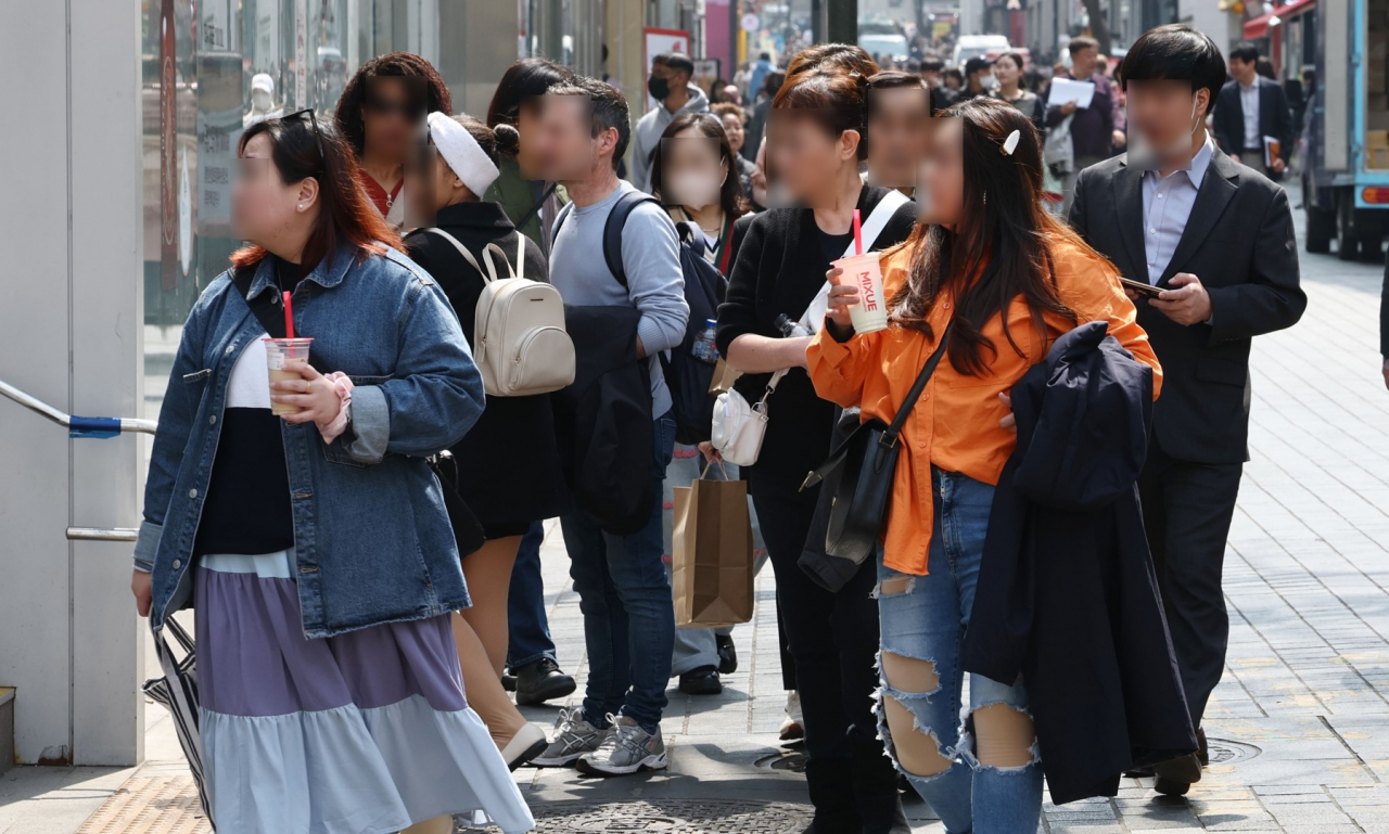 This photo shows travelers in the Myeong-dong shopping district in central Seoul on March 29. (Yonhap)