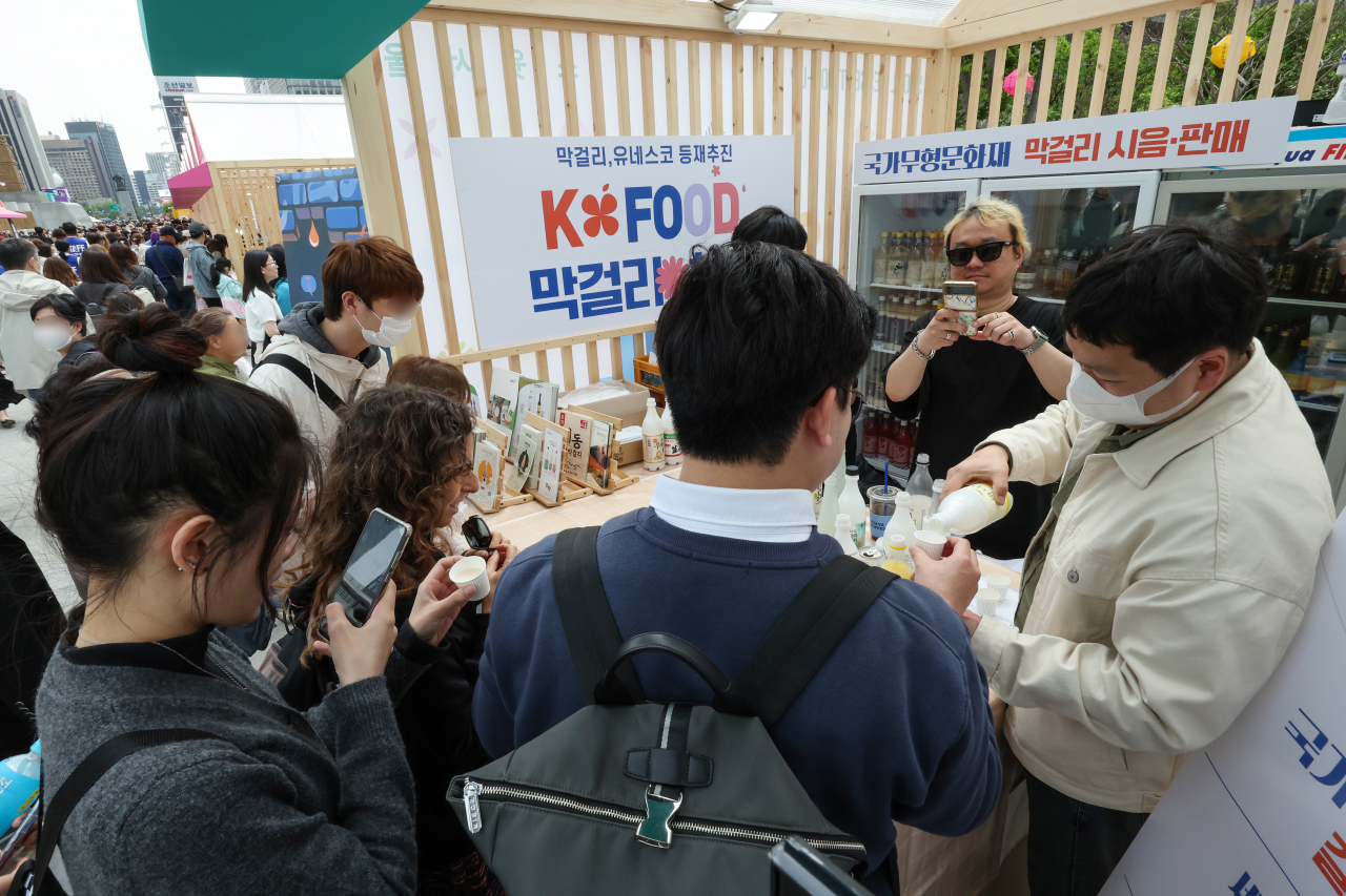 Visitors are seen tasting Makgeolli, traditional Korean alcoholic beverage, at the Gwanghwamun Plaza in central Seoul, the main venue of “Seoul Festa 2023,” on Sunday. (Yonhap)