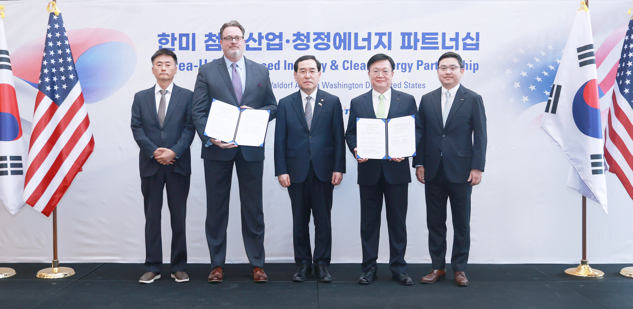 Ed Moland (second from left), vice president of Rockwell Automation, South Korea's Trade, Industry and Energy Minister Lee Chang-yang (center), and Doosan Corp. President Moon Hong-sung (third from left) pose for a photo after signing an agreement in Washington on April 25. (Doosan Corp.)