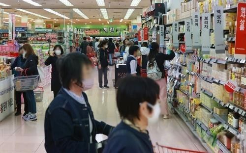 This file photo shows people shopping for groceries at a discount store in Seoul on April 13. (Yonhap)